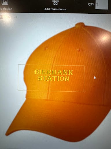 Orange cap with yellow embroidered text reading Bierbank Station