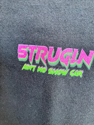 Embroidered pink and green STRUGLING text on dark grey hoodie