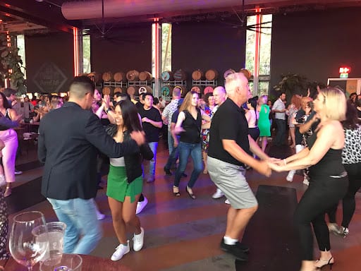 Crowd of people dancing together at an indoor event venue